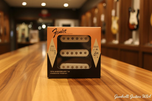 Fender 70th Anniversary '24 Stratocaster humbucker pickups in their original orange and black packaging, displayed on a dark textured surface.